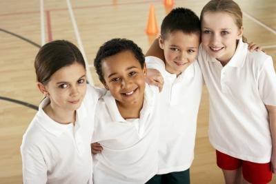 A group of friends with their arms around eachother in a school gym.