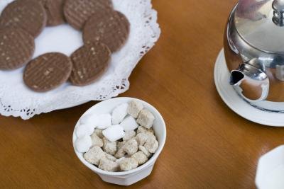 Light brown evaporated cane juice cubes and refined white sugar cubes in a bowl.
