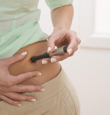 A woman gives herself an insulin shot.