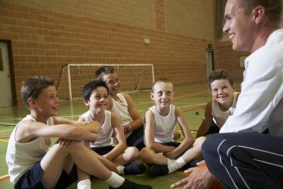 Boy sitting around PE teacher