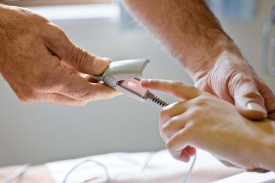Patient in hospital having pulse measured.
