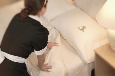 Hotel maid making the bed