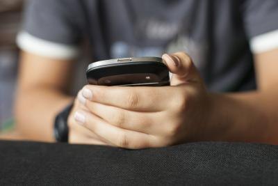 A close-up of a boy holding a smart phone.