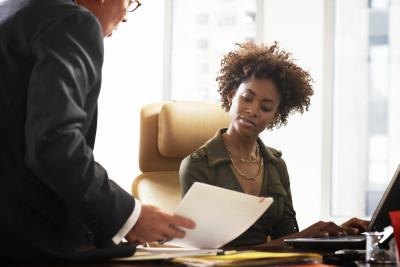 A boss speaks with an administrative assistant.