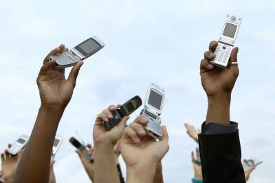 people holding up old cell phones