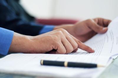 A man reads a contract before signing it.