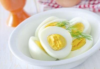 A bowl of hard boiled eggs cut in half.