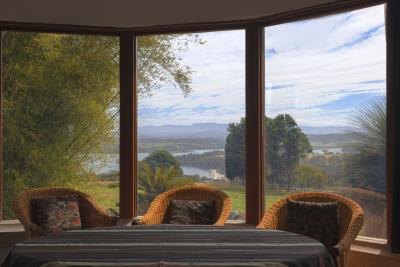 A wall of large windows in the lounge room of a cottage.