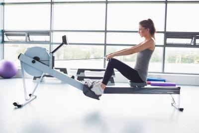 A woman is using a rowing machine at the gym.