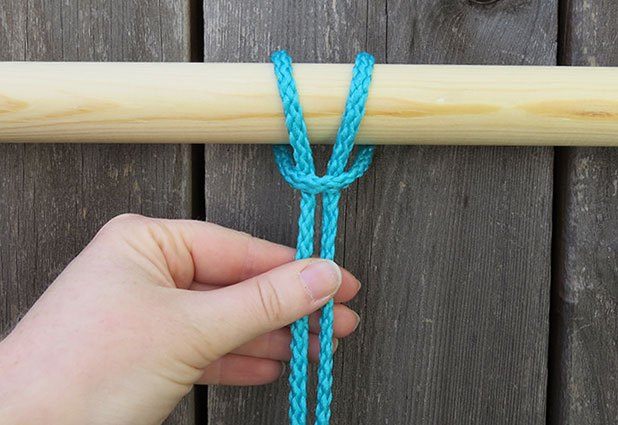 Wrap the loop around the dowel and pull the tails through.