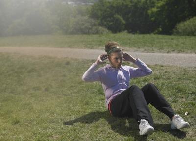 Young woman doing sit ups on the grass Young woman doing sit ups on the grass