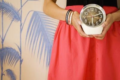 Women holding clock Women holding clock