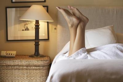 Woman lying on bed with feet up Woman lying on bed with feet up