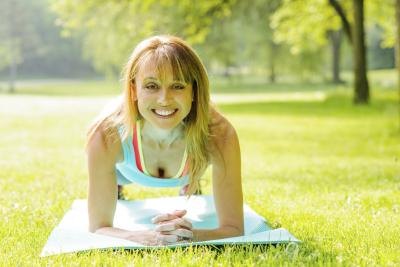 Woman holding the plank position outside at park. Woman holding the plank position outside at park.