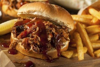 Pulled pork sandwich with barbecue sauce and french fries Pulled pork sandwich with barbecue sauce and french fries