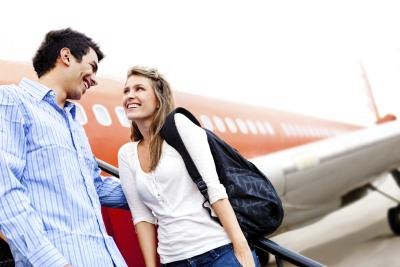 Happy couple next to airplane Happy couple next to airplane