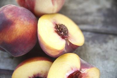 Cut peaches on a wooden table. Cut peaches on a wooden table.