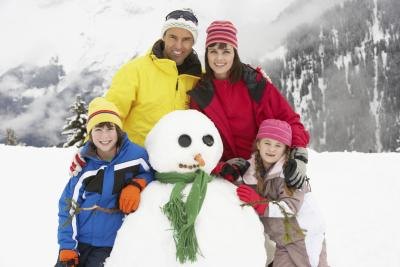 family making snowman on vacation family making snowman on vacation