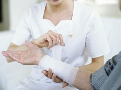 Man having bandage wrapped on arm Man having bandage wrapped on arm