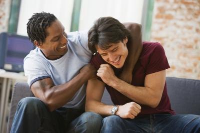 Two men pretend wrestling on couch. Two men pretend wrestling on couch.