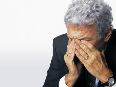 A man holds his head in pain. A man holds his head in pain.