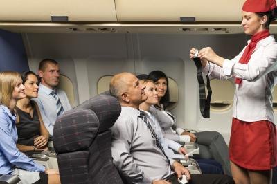 Flight attendant giving seatbelt demonstration on aircraft Flight attendant giving seatbelt demonstration on aircraft