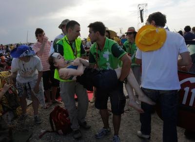 Woman suffering from heat exhaustion is carried to ambulance Woman suffering from heat exhaustion is carried to ambulance
