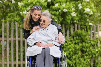 Young woman hugging nursing home resident Young woman hugging nursing home resident