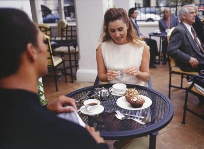 Co-workers eating pastries at an outdoor cafe table. Co-workers eating pastries at an outdoor cafe table.