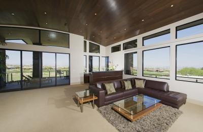 Glass -topped end tables beside brown leather couch Glass -topped end tables beside brown leather couch
