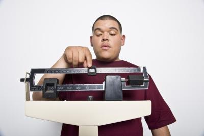 Teenage boy weighing himself. Teenage boy weighing himself.