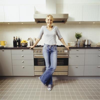 A happy woman stands in her kitchen. A happy woman stands in her kitchen.