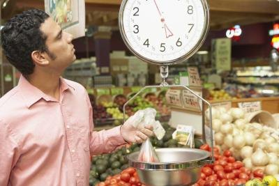 Man weight vegetables in grocery store. Man weight vegetables in grocery store.