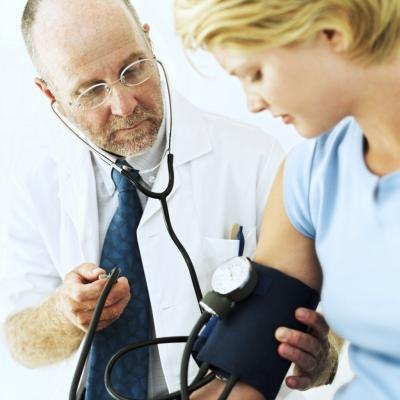 A doctor takes a woman's blood pressure. A doctor takes a woman's blood pressure.