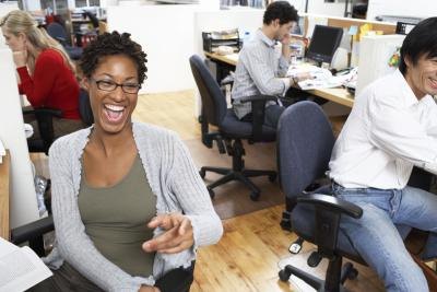 Co-workers laughing in an office. Co-workers laughing in an office.