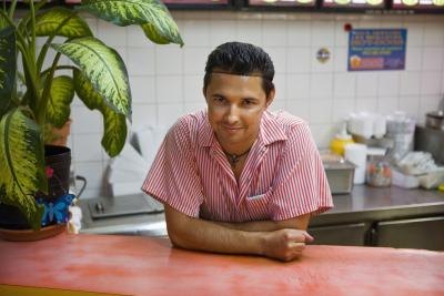 A cook in the kitchen of a diner is ready for a new order. A cook in the kitchen of a diner is ready for a new order.