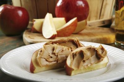 Apple slices with peanut butter on a plate. Apple slices with peanut butter on a plate.