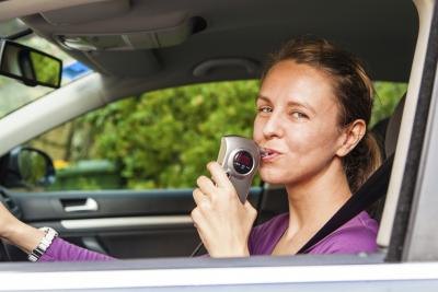 woman taking breathalyzer test woman taking breathalyzer test