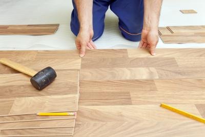 Man installing wood laminate floor Man installing wood laminate floor
