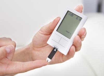 Woman testing her blood sugar level Woman testing her blood sugar level