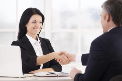 Woman shaking sponsor's hand to seal the deal in business office Woman shaking sponsor's hand to seal the deal in business office