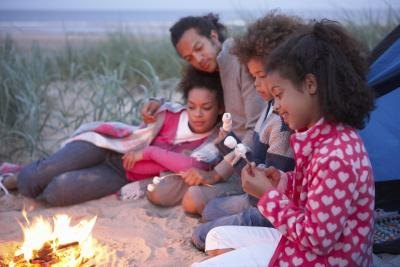 A family by the fire camping out on the beach. A family by the fire camping out on the beach.