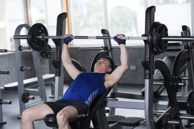 Man bench pressing weights in a gym