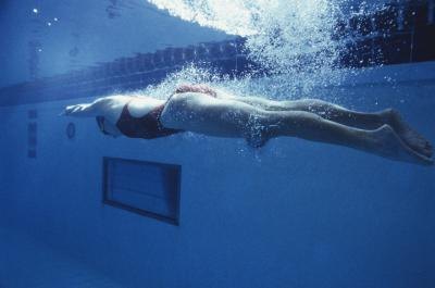 Woman pushing off wall in pool