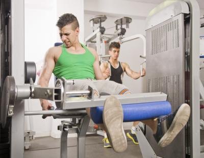 Young man doing quad exercises in gym