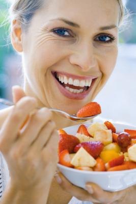 Woman eating a bowl of fruit