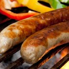 Grilled sausages in a pan on wooden background