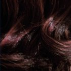 Cropped head shot of woman with wet red hair dye