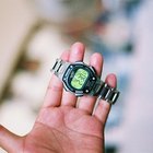 Mid adult man standing at street, looking at watch