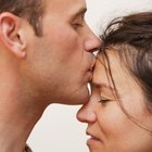 Couple sitting apart on bed, night